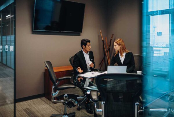 Employees sitting in conference room talking