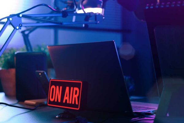 TV broadcasting on air sign in front of laptop on desk